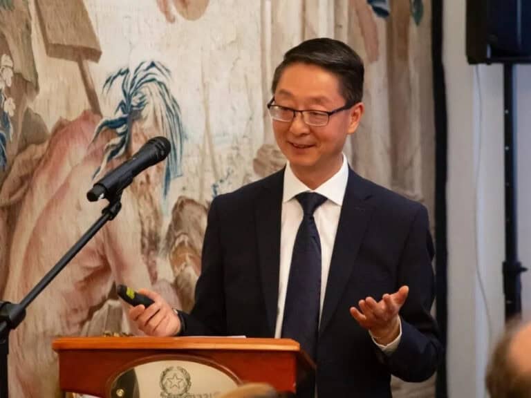 Man in suit giving a presentation on diversity and inclusion at a professional event.