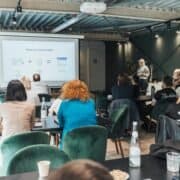 Trainer presenting to a group during a professional workshop in a modern venue.