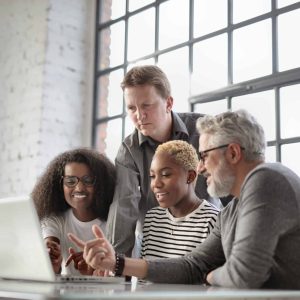 Diverse team engaging in professional employee training via laptop, promoting corporate programs and online learning.