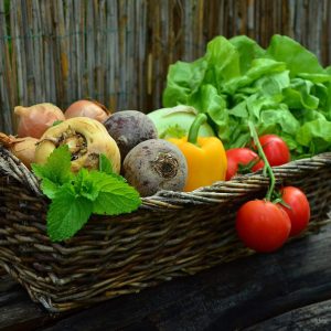 Fruits and vegetables in a woven basket for online workforce development training programs at London Intercultural Academy.